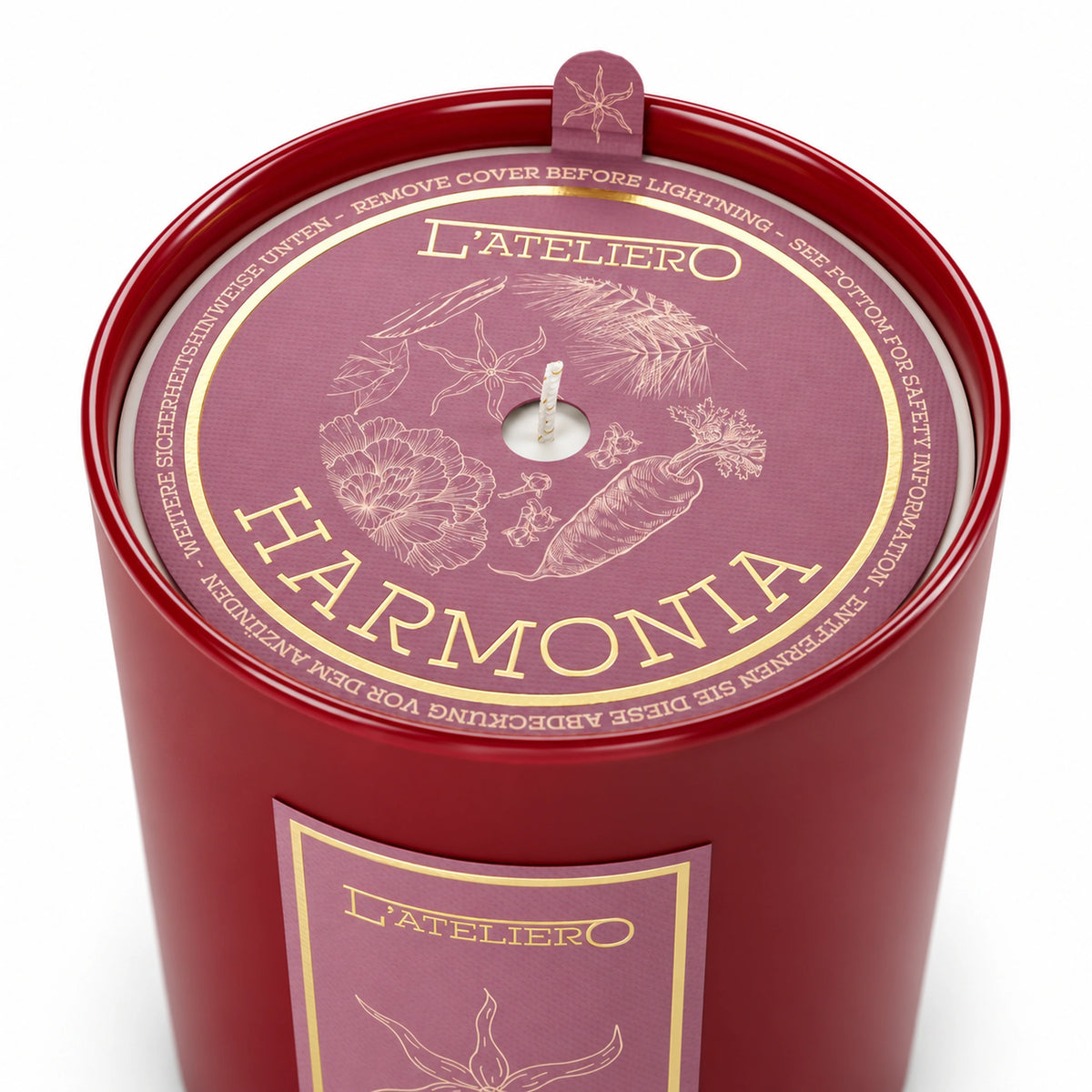 L’ATELIERO Harmonia Duftkerze schräg von oben: rotes Glas und rosafarbene Schutzabdeckung mit goldenen botanischen Zeichnungen.